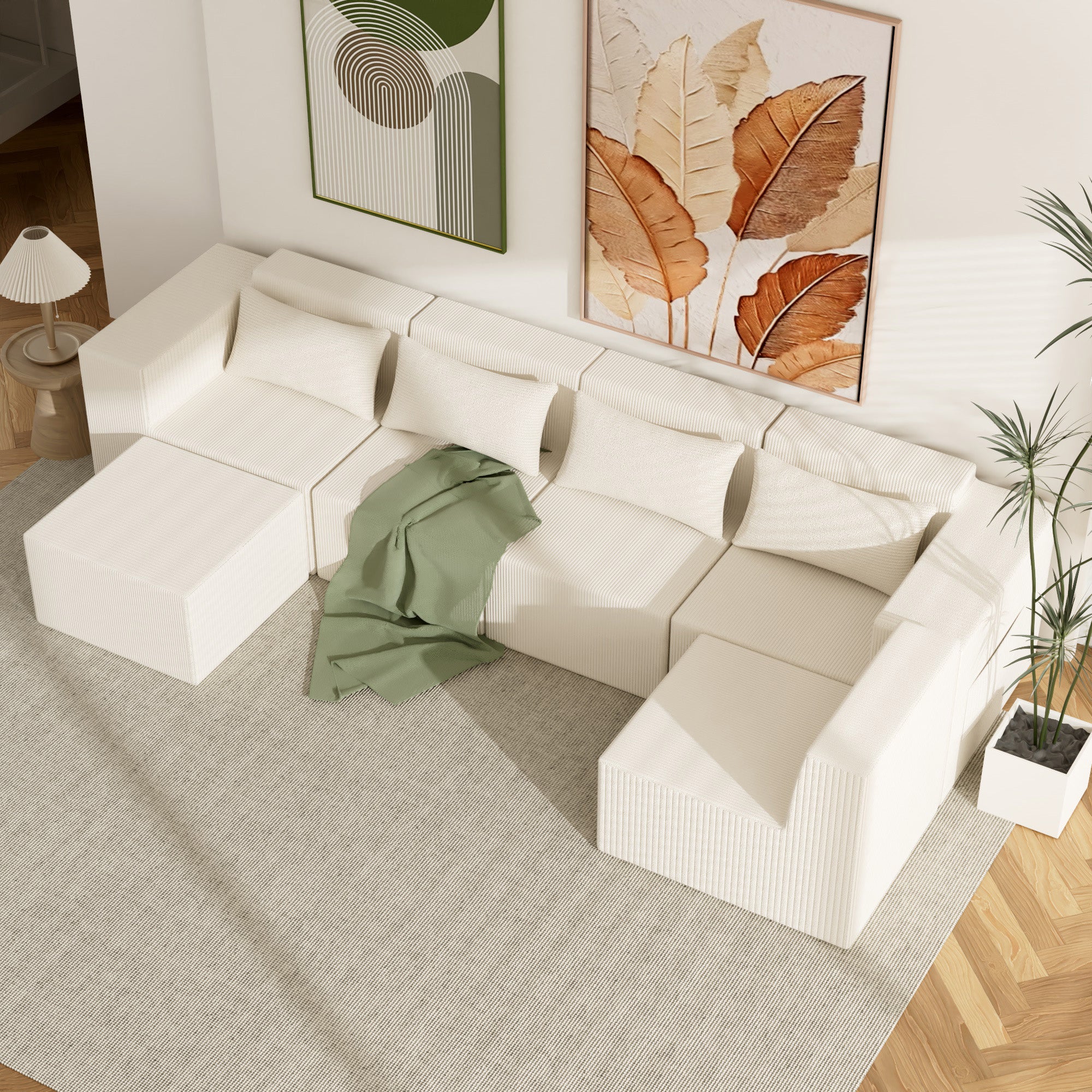 White sectional sofa in a living room with abstract art on the wall.