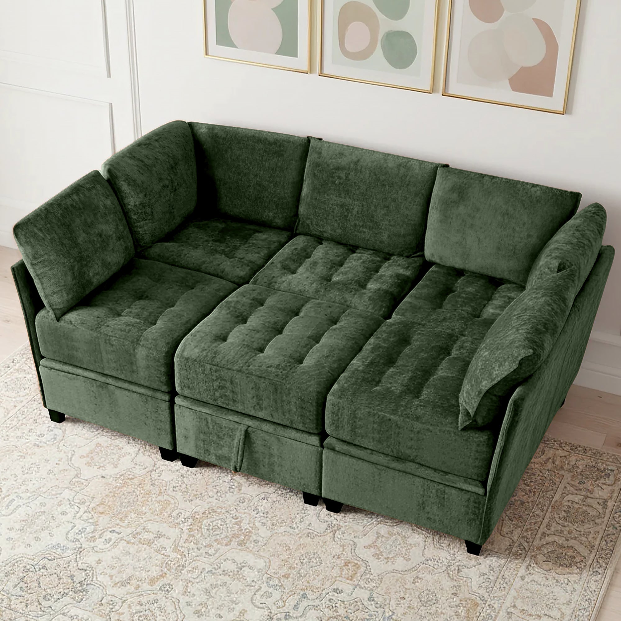 Green sectional sofa in a living room setting with framed artwork on the wall.