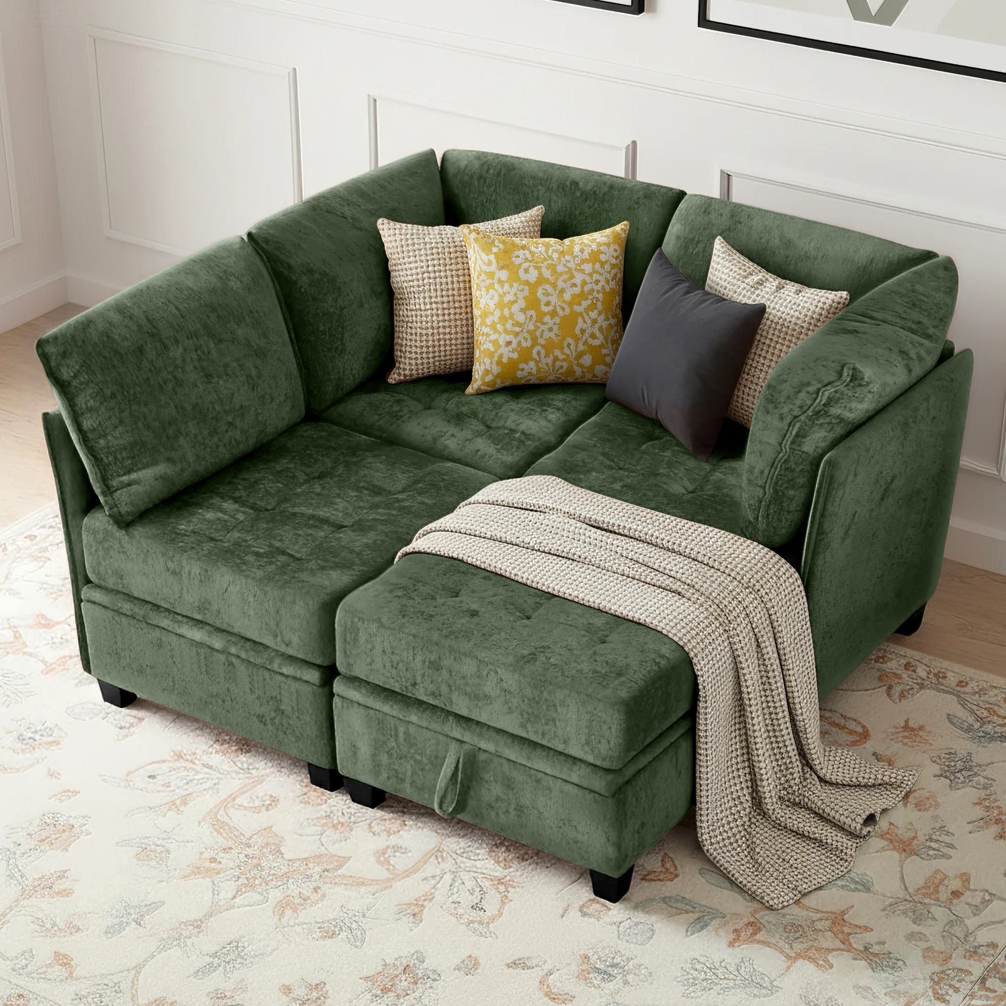 Green sectional sofa with cushions and a blanket on a patterned rug.