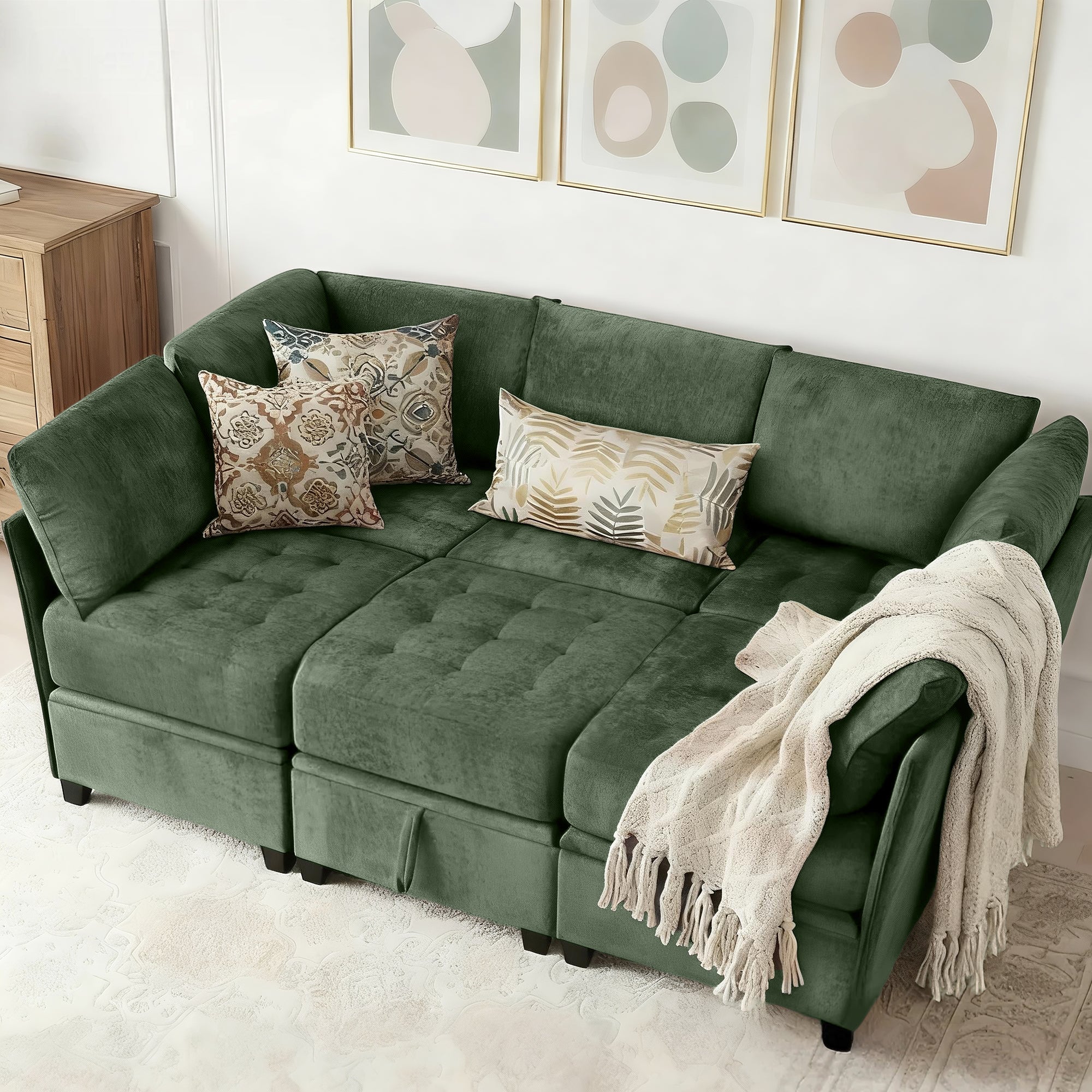 Green sectional sofa with patterned pillows and a blanket in a living room setting.