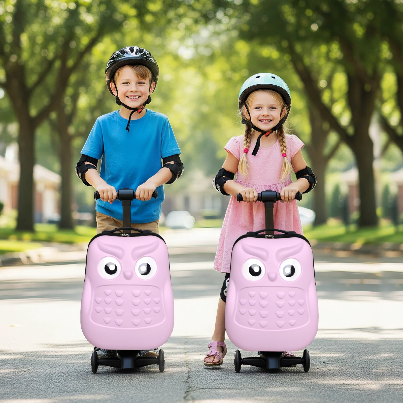 Two children with pink owl-shaped suitcases on wheels in a park setting.