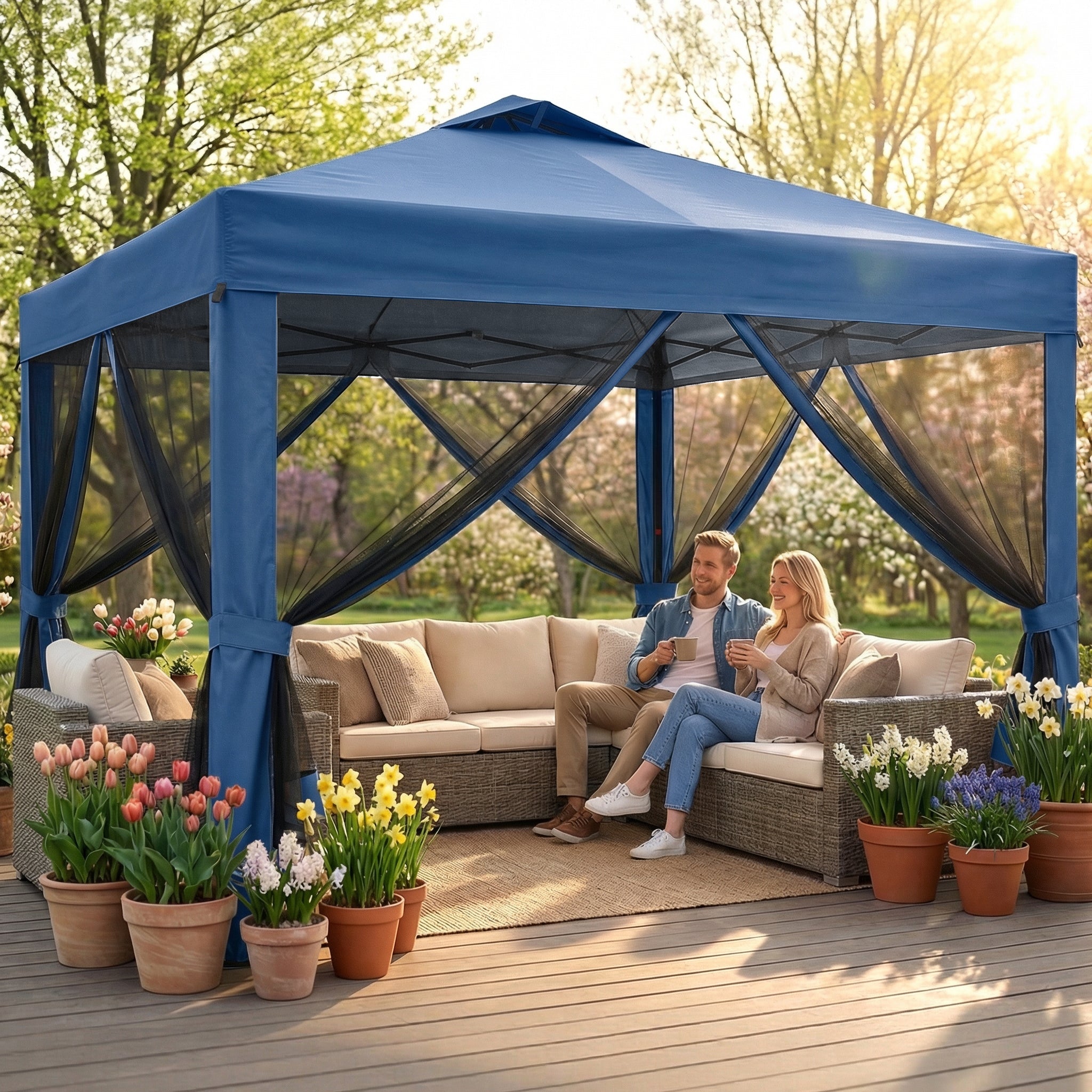 Blue gazebo with a couple sitting on a couch, surrounded by potted plants and flowers.