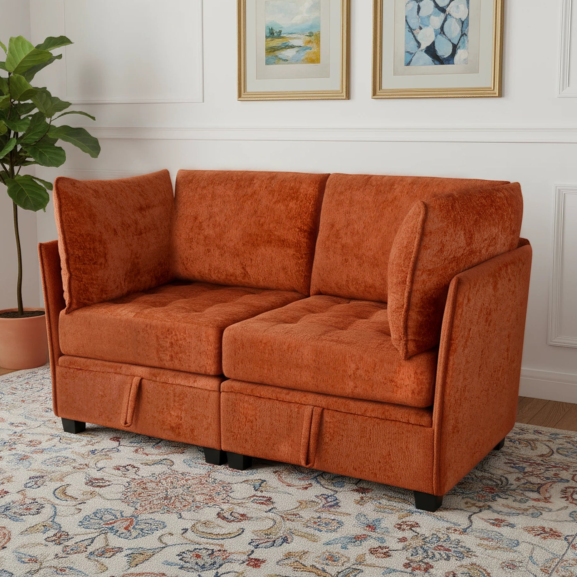Orange sofa in a living room with a plant and framed pictures on the wall.