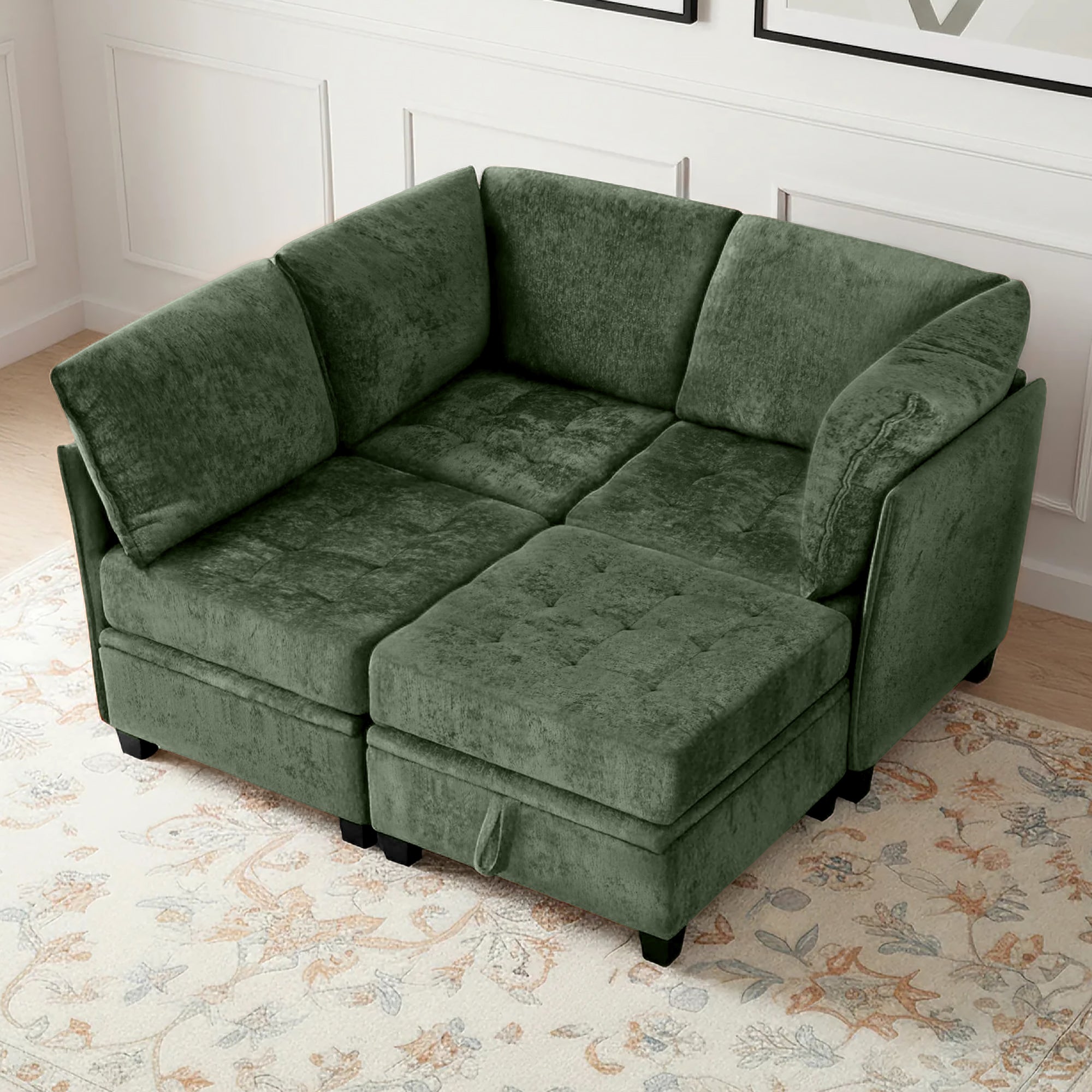 Green sectional sofa in a room with a floral rug and white walls.