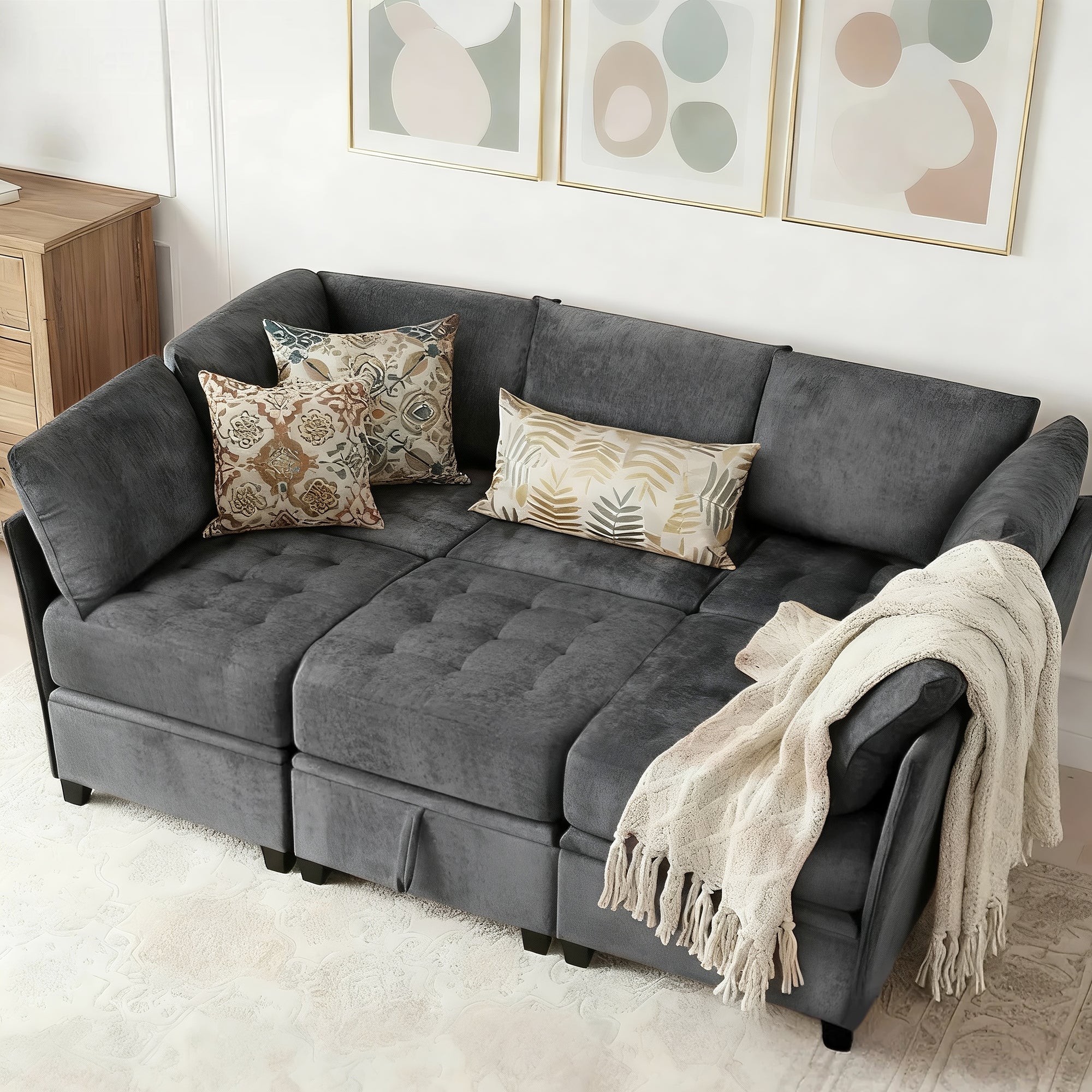 Gray sectional sofa with decorative pillows and a blanket in a living room setting.