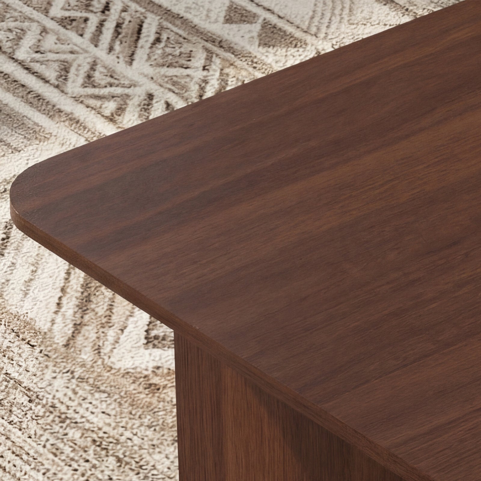Close-up of a wooden table corner on a textured beige rug